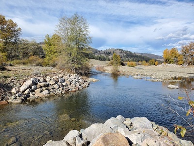 Confluence of Sugar Creek with the main stem Scott River, with rocky banks and autumn trees.