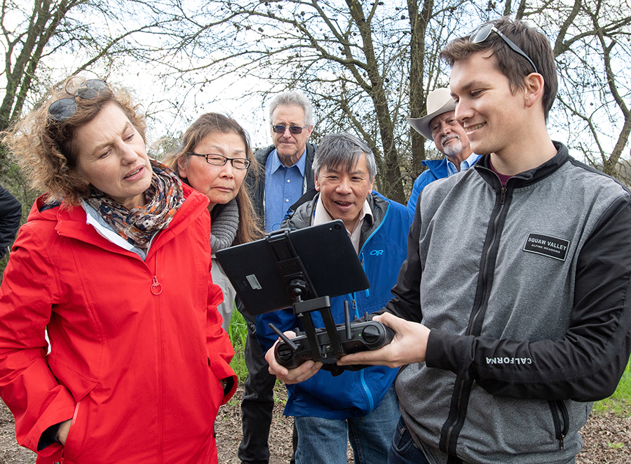 From left, California Water Commission Assistant Executive Officer Jennifer Ruffolo, Commissioner Carol Baker, Public Information Officer Paul Cambra, Executive Officer Joe Yun, and Commissioner Joe Del Bosque watch live video feed from a drone operated by University of California, Merced Researcher Michael Kalua, Jr. at the Oneto-Denier Floodplain Restoration Project in the Cosumnes River Watershed near Galt.