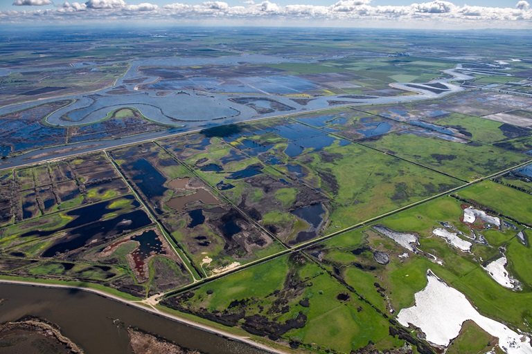 Aerial view looking east Holland Tract in foreground then Old river and Bacon Island in background, part of the Sacramento-San Joaquin River Delta in San Joaquin County, California.