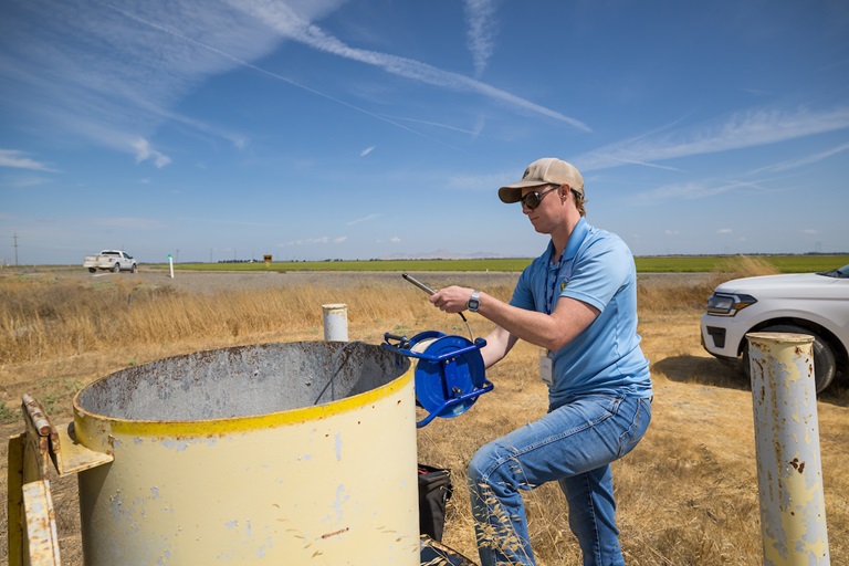 California Department of Water Resources Groundwater Hydrogeologist Ky Dupuis, from the Geology and Groundwater Investigations Section of the Division of Regional Assistance North Central Region Office, works on their routine groundwater monitoring well run in Colusa County. Photo taken August 23, 2024.
