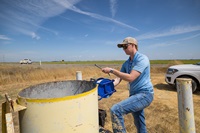 California Department of Water Resources Groundwater Hydrogeologist Ky Dupuis, from the Geology and Groundwater Investigations Section of the Division of Regional Assistance North Central Region Office, works on their routine groundwater monitoring well run in Colusa County. Photo taken August 23, 2024.