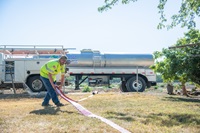 Scott Bambauer of Bambauer Towing delivers water to fill a 1500 gallon potable water tank at a residence in Glenn County, California, where wells have run dry.”