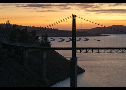 A drone view after sunset of Bidwell Bar Bridge with Bidwell Canyon Marina in the background at Lake Oroville.