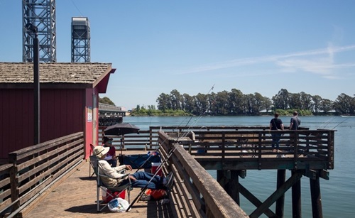 Rio Vista, California features a popular fishing pier next to the Rio Vista Bridge over the Sacramento River.
