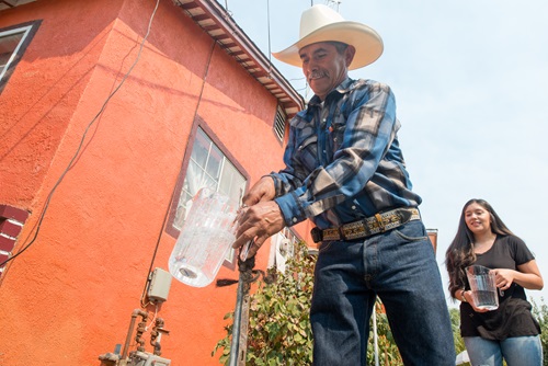 Photo of Leonicio Ramirez and his daughter Tania Ramirez as the first residents to receive water through a water distribution system in East Porterville California.