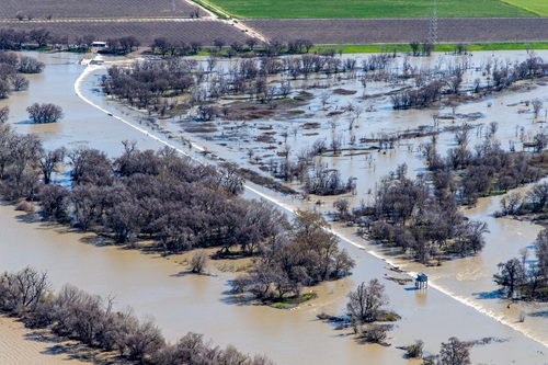 The Fremont Weir Adult Fish Passage control tower stands above water overtopping the Fremont Weir and entering the Yolo Bypass. Taken February 27, 2024.